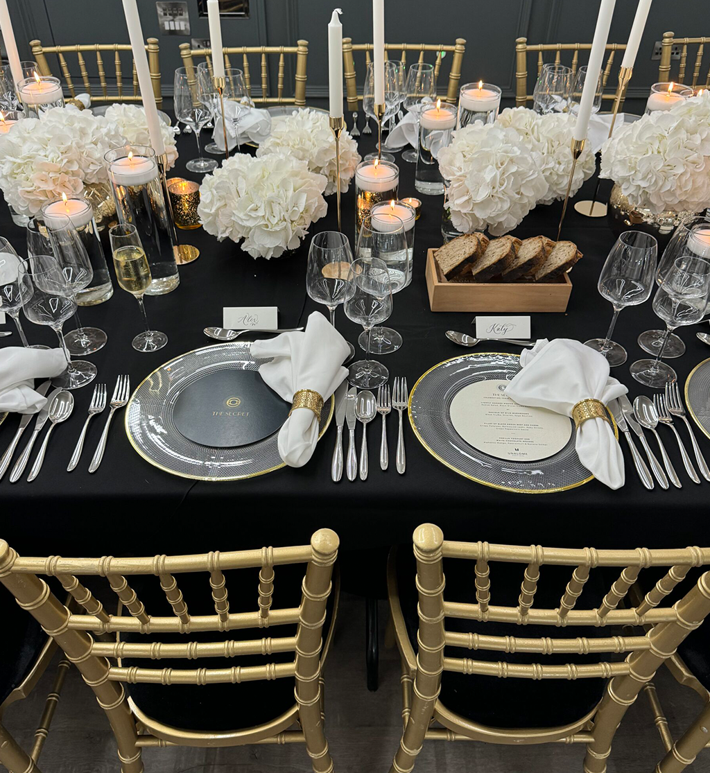 Luxury black and gold event table styling with candlelight, hydrangea centrepieces and elegant place settings by Muse Styling Scotland