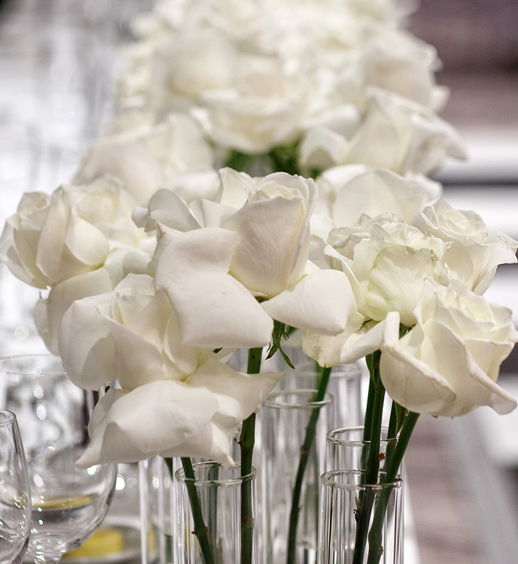 White rose centrepieces in glass vases on wedding table at Cameron House by Muse Styling