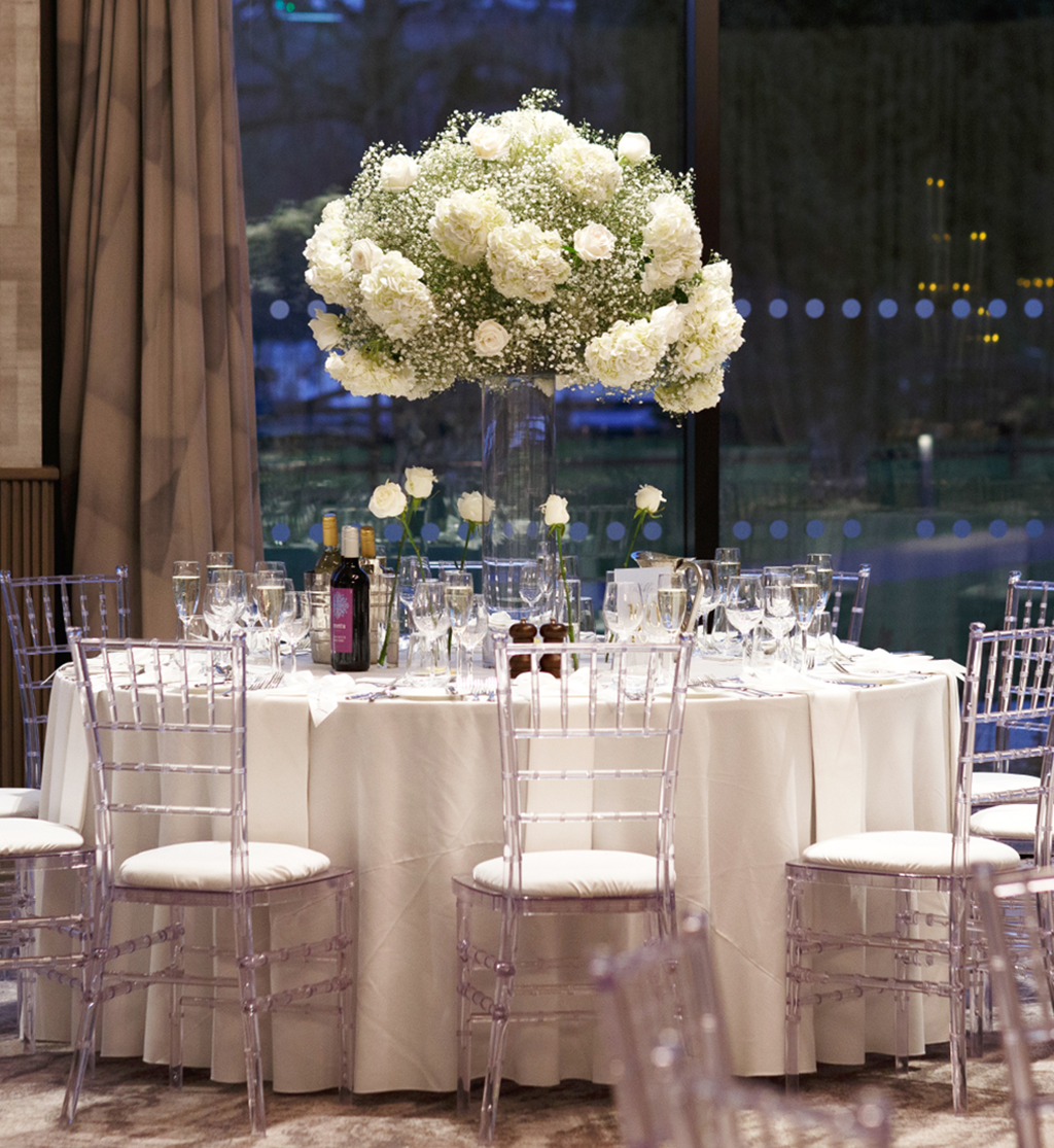 Wedding reception table with tall white floral centrepiece and Chiavari chairs at Cameron House by Muse Styling