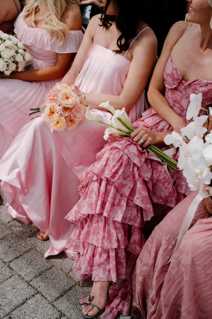 Bridesmaids carrying blush rose and white orchid bouquets at a luxury destination wedding in Scotland.